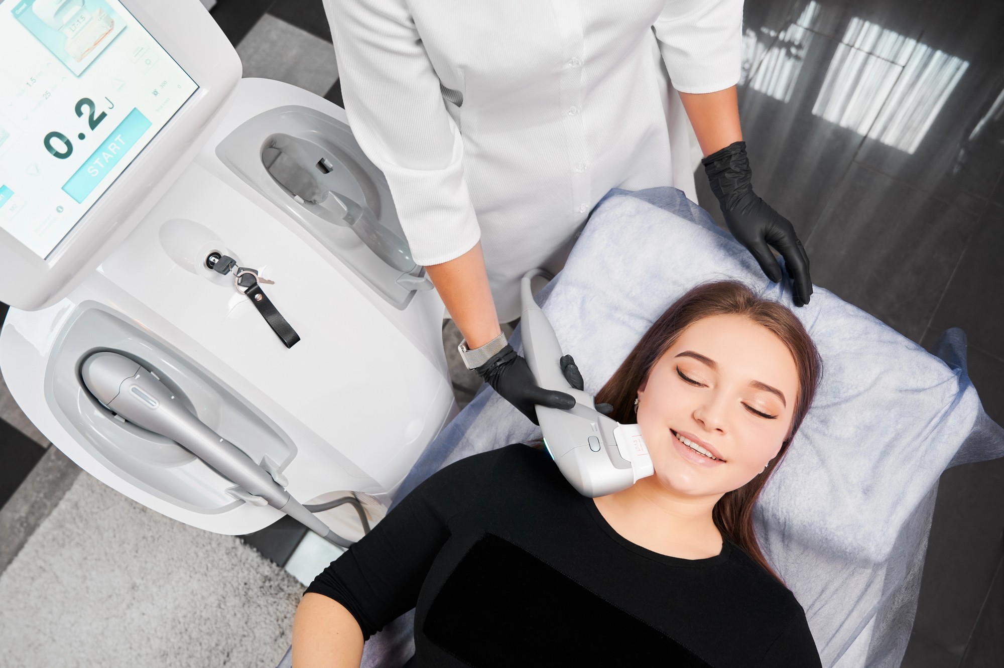 HIFU treatment in progress: handpiece delivering focused ultrasound energy along the jawline